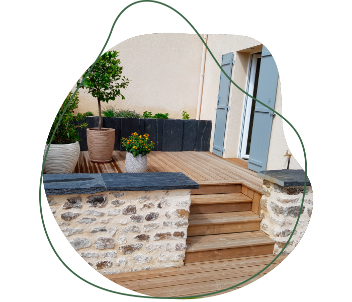 Terrasse en bois avec marches, jardinières minérales et aménagement paysager réalisé par Jardins du Moulin